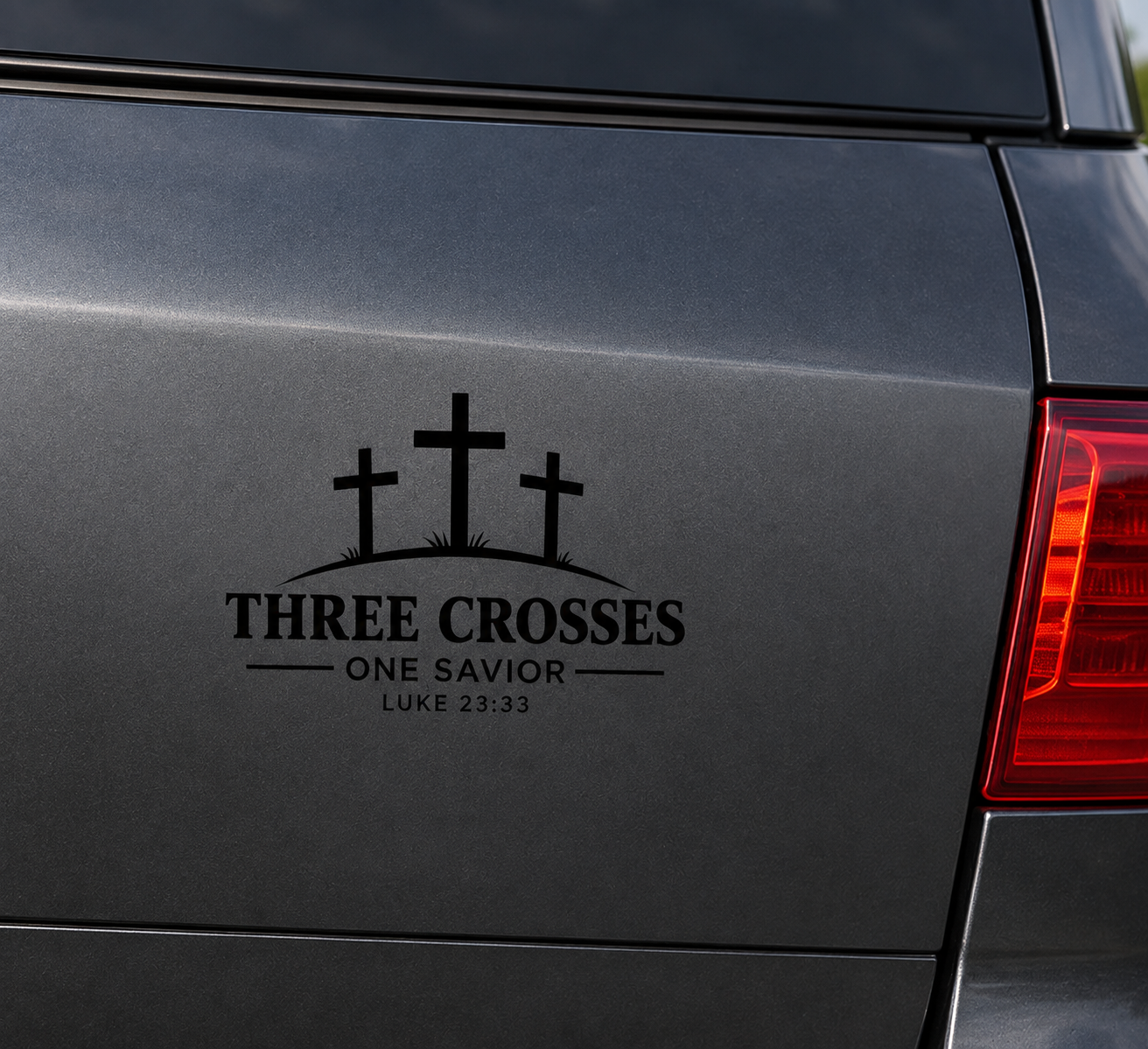 Three Crosses One Savior Christian vinyl decal in white displayed on a dark grey vehicle body panel.