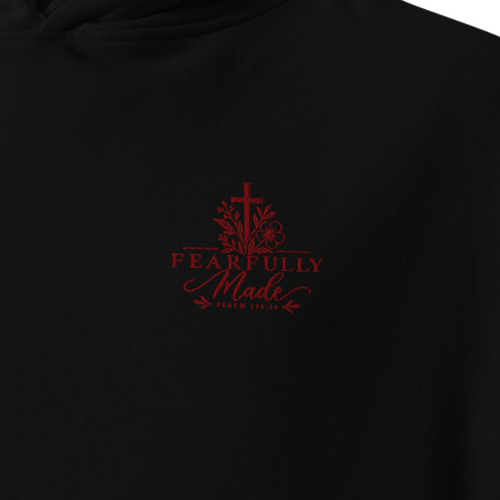 Close-up of black Fearfully Made Psalm 139:14 premium embroidered Christian hoodie with red cross and floral chest embroidery.