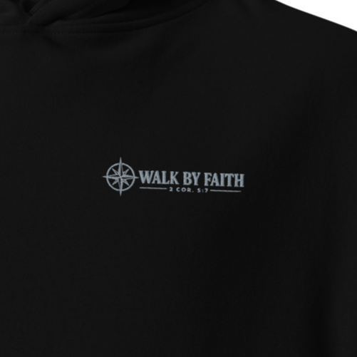 Close-up of black Walk by Faith 2 Corinthians 5:7 premium embroidered Christian hoodie with silver compass chest embroidery.
