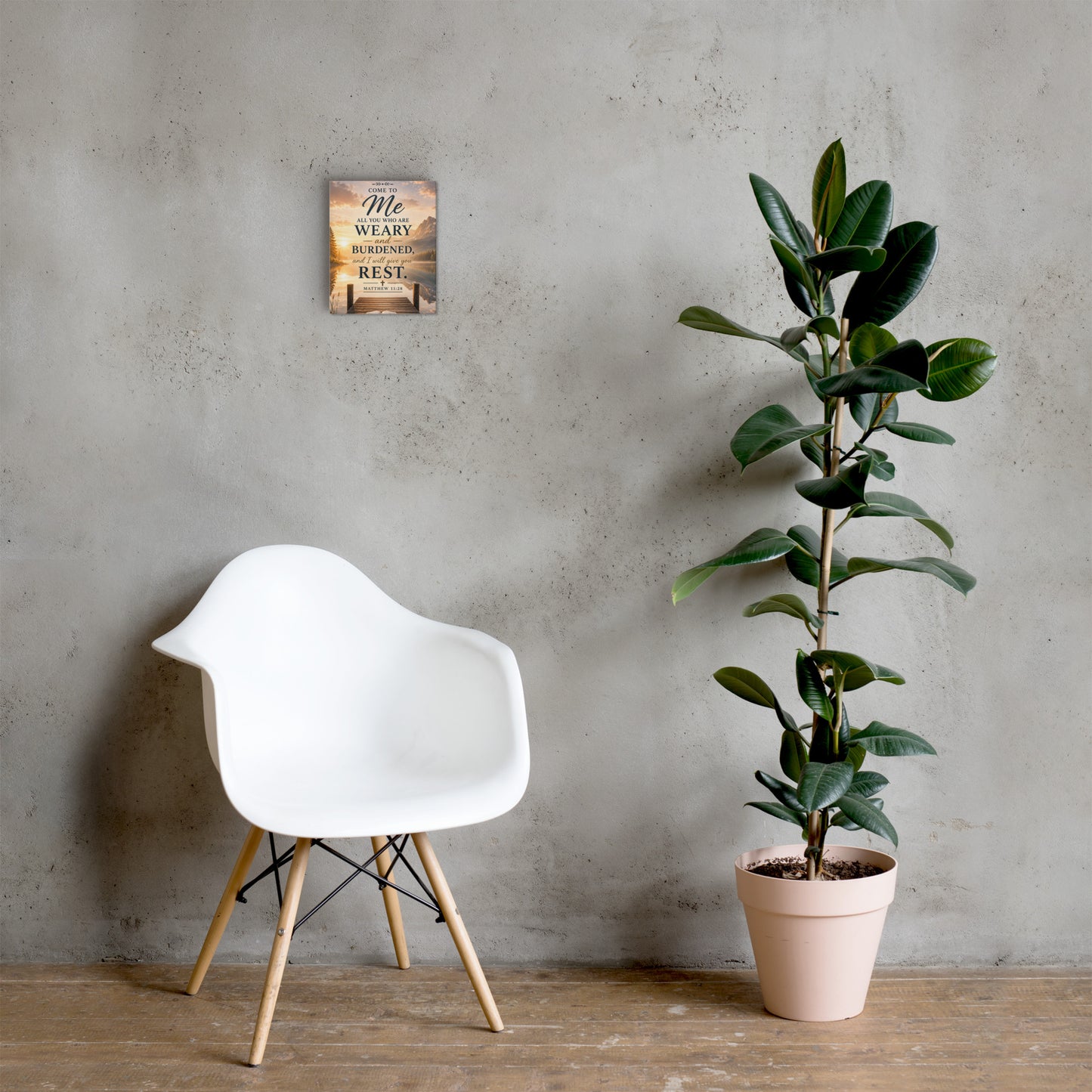 Matthew 11:28 Bible verse canvas displayed beside white chair and green plant