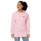 Woman modeling Light Pink He First Loved Us women's Christian embroidered hoodie